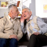 Two men sat together struggling to hear