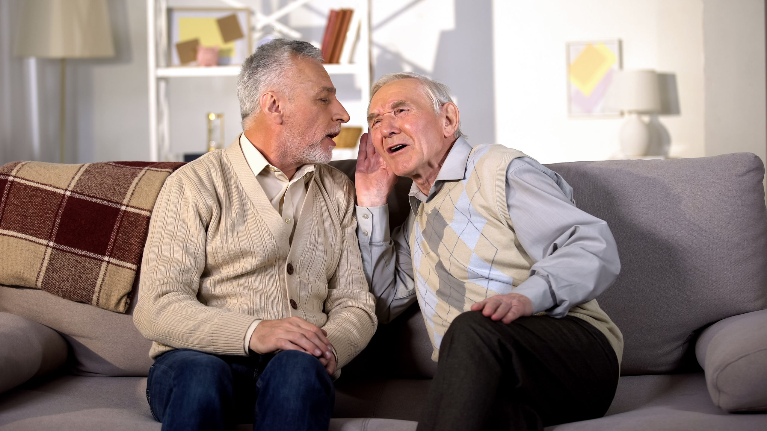 Two men sat together struggling to hear