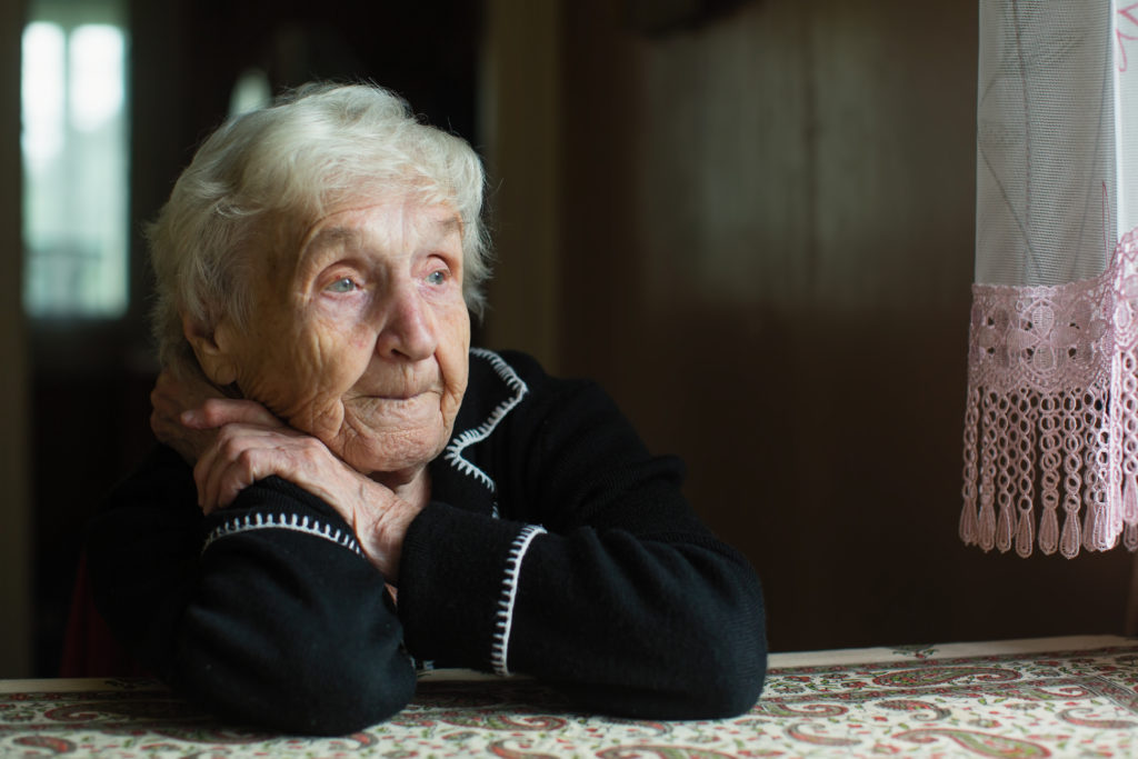 Elderly lady alone looking out the window