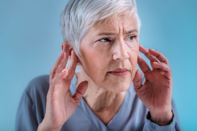 A woman holding her hands to her ears