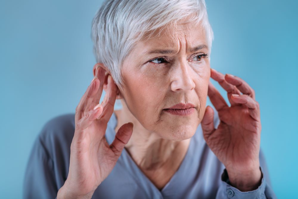 A woman holding her hands to her ears