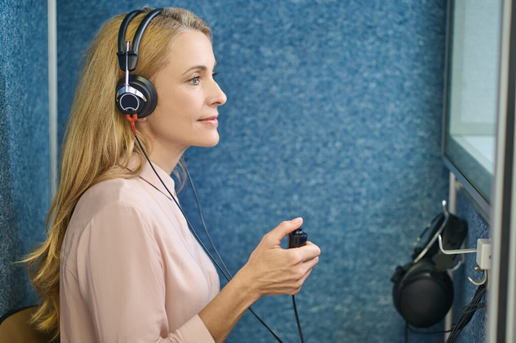 A woman sat sideways taking a hearing test