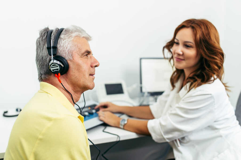 Senior man at a hearing consultation with an audiologist.